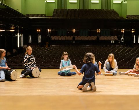 Kinder sitzen nebeneinander auf der Bühne und musizieren Fotocredit himmelrenner